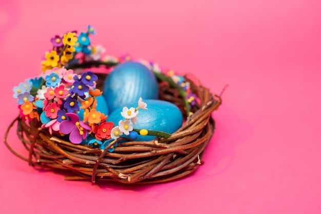 Three blue eggs in nest of flowering branches