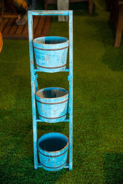 Three blue flower pots on a ladder