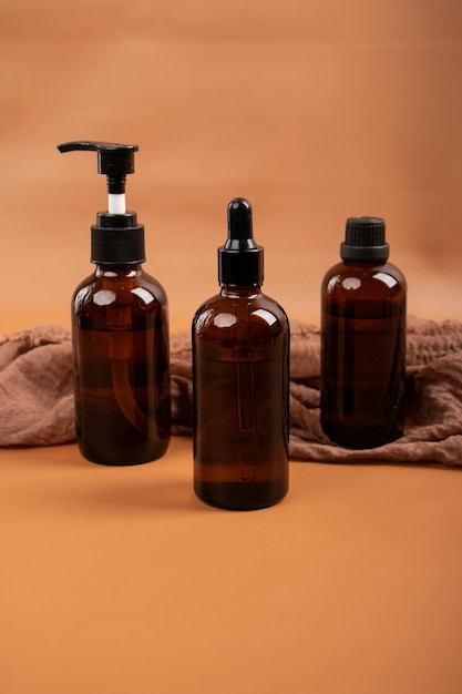 three bottles of shampoo are on a brown towel