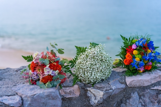 Три букета цветов с свадебной церемонии в красивых цветах. Море на горизонте