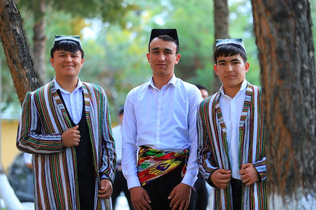 three boys wearing traditional clothing with the word tuk on the front