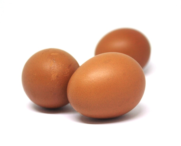 Foto tre uova marroni sono su uno sfondo bianco