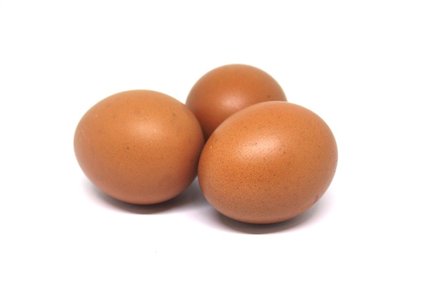 Three brown eggs on a white background