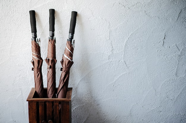 Three brown umbrellas in a wooden basket