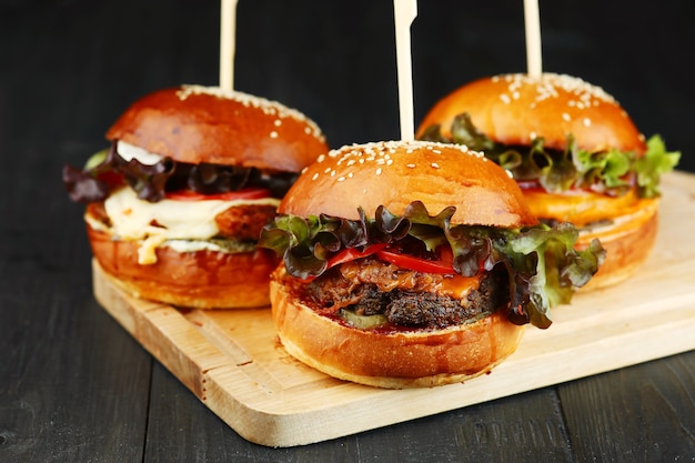 Three burger on wood. set of burger on wooden deck closeup.