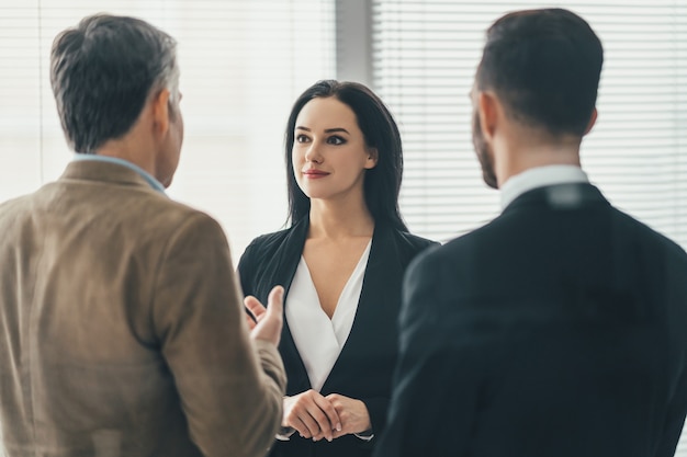 The three business people discussing in the office