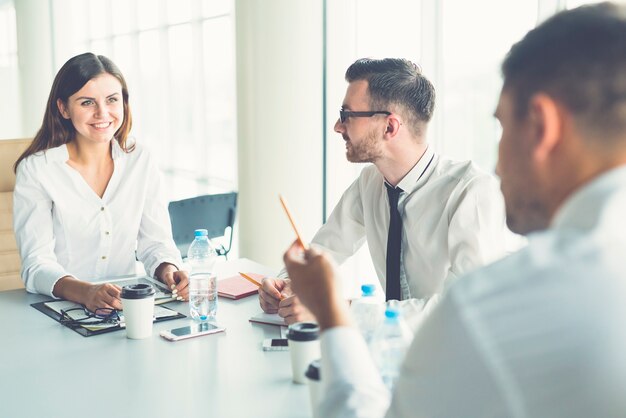 The three business people talk at the table