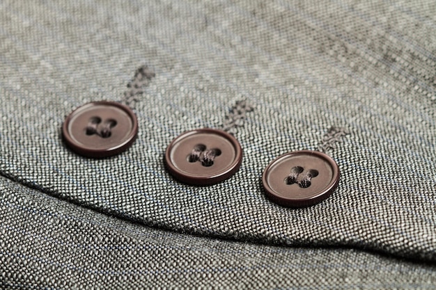 Three buttons of a gray suit in a close up view