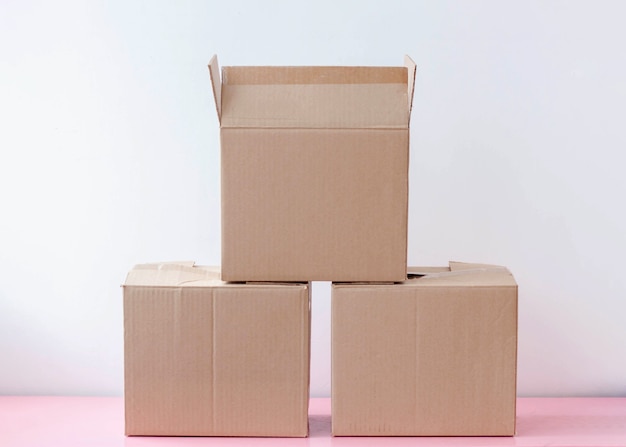Foto tre scatole di cartone per l'imballaggio stanno su uno sfondo bianco una sopra l'altra.