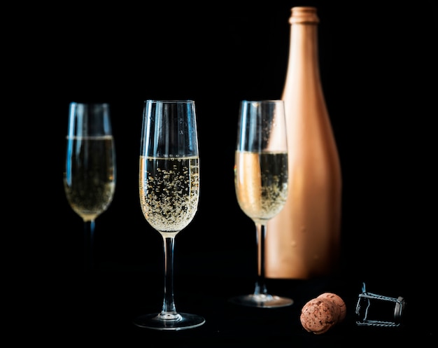 Three champagne glasses with bottle