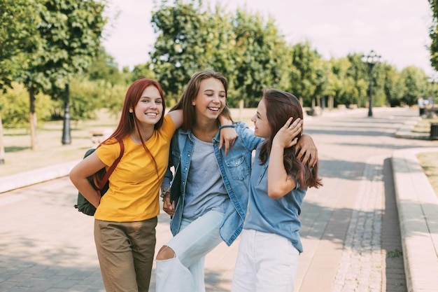 写真 3人の陽気なティーンエイジャーの女の子が学校から来る 訓練と教育の概念