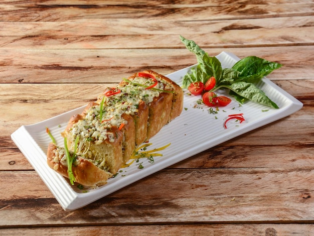 Three cheese garlic bread or baguette consists of bread topped\
with cheese garlic olive oil and herbs served over a rustic wooden\
background selective focus