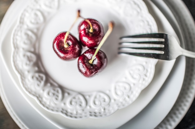 Three cherries on a porcelain dish