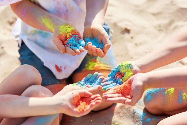 Three children holding colorful powder in hands