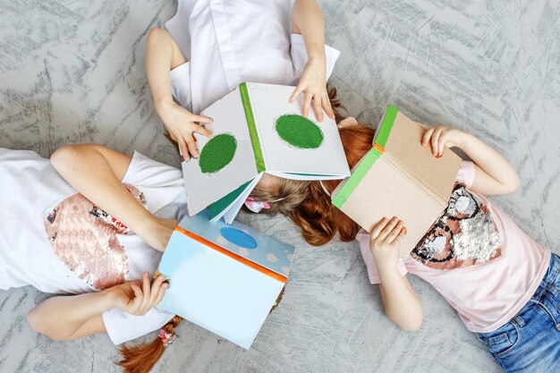 Foto tre figli di studenti con libri preparazione per gli esami th