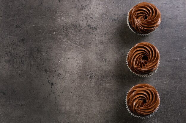 Three chocolate cupcakes on grey