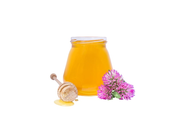 three clover flowers next to a jar of honey on a white background