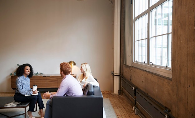 Tre colleghi a una riunione di lavoro informale in un'area lounge