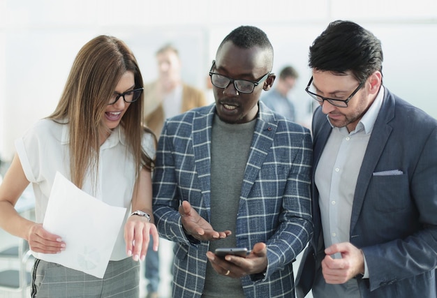 Three colleagues looking at the smartphone screenpeople and technology