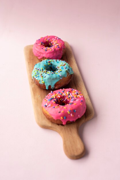 three colored donuts on a wooden table