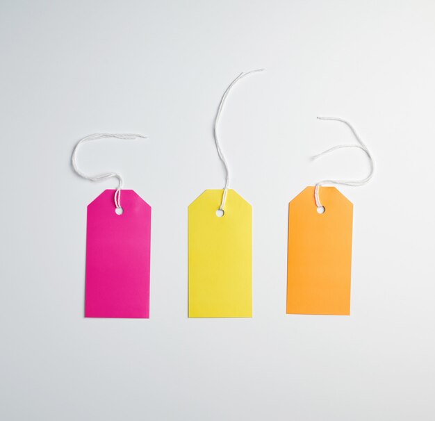 Three colored paper tags on a white rope