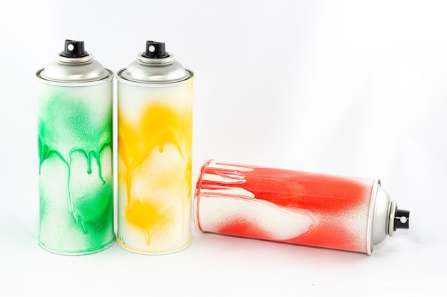 Tre barattoli di vernice spray colorata su sfondo bianco