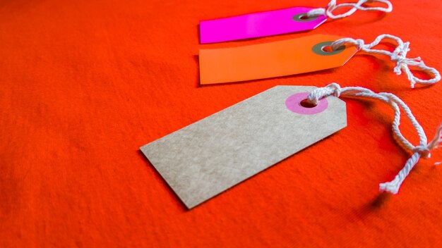 Photo three colored tags on a white rope, red background