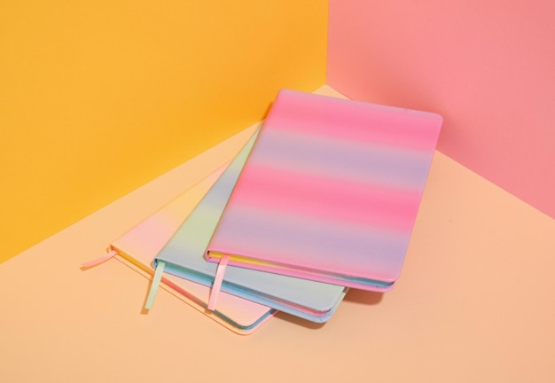 Three colorful brightly colored notebooks on the table Variety of school supplies