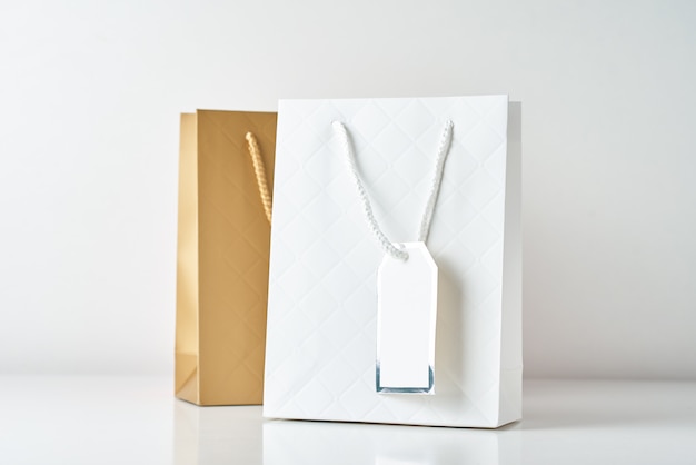 Three colorful paper shopping bag on a white wall