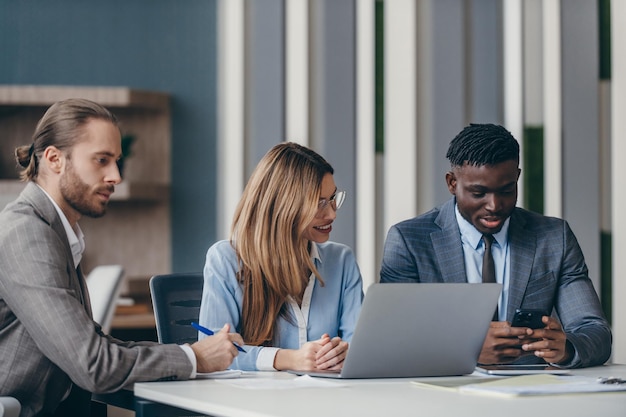 Three confident business people discussing strategy while having group meeting at the office desk