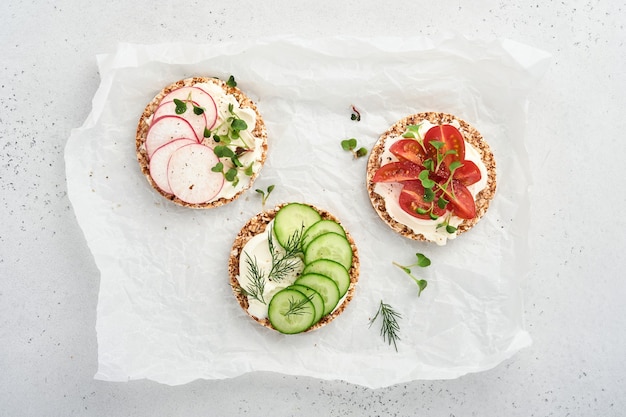 three crispy buckwheat bread gluten free with cream cheese, radish, tomato cucumber and microgreen