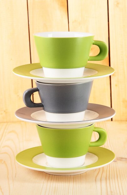 Photo three cups on wooden background