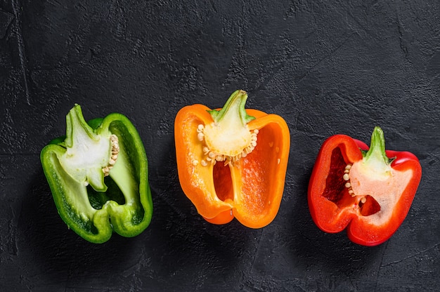 Three cut orange, green and red sweet peppers.