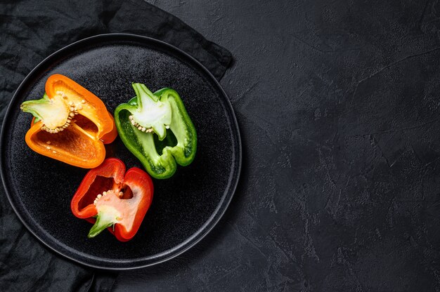 Three cut orange, green and red sweet peppers.