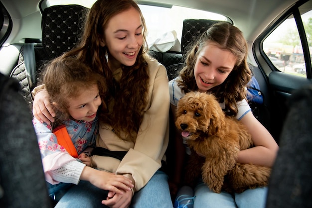 Three cute girls and dog in the car