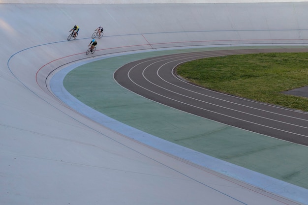 3명의 사이클 선수가 우크라이나 키예프에서 원을 그리며 사이클 트랙에서 경쟁하고 있습니다.