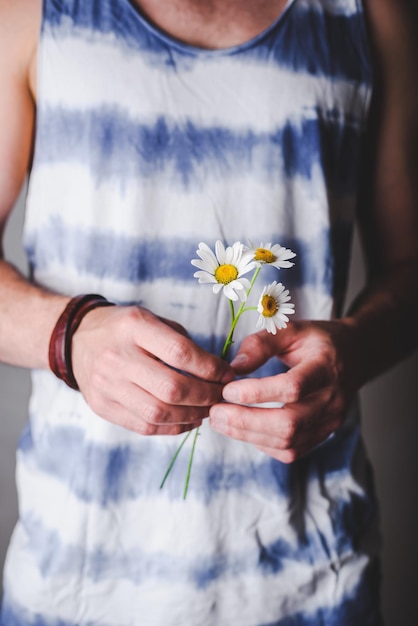 Photo three daisy flowers in male hands