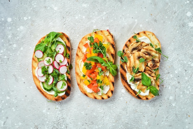 Три вкусных цветных домашних бутерброда на каменном фоне Вид сверху