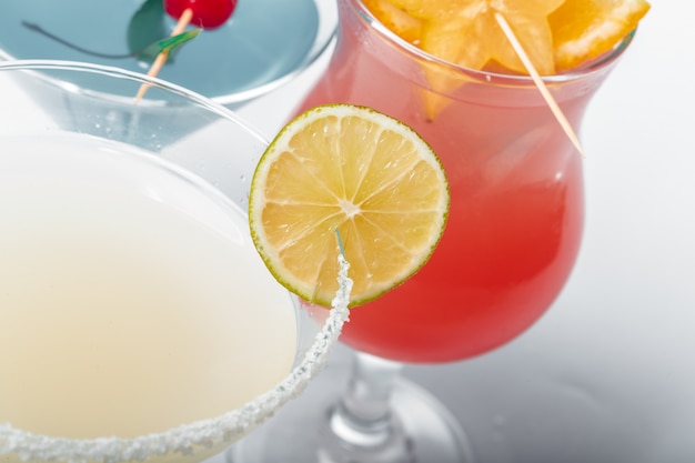 Three different alcoholic cocktails on a white 