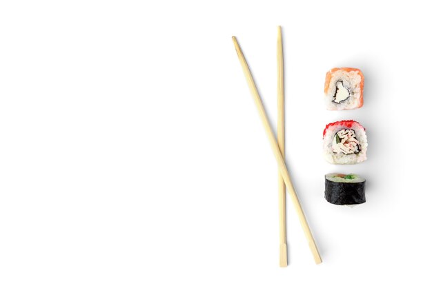 Three different sushi rolls and wooden chopsticks isolated on white background.