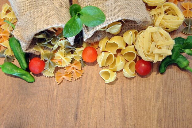 Three different types of colored pasta on wood