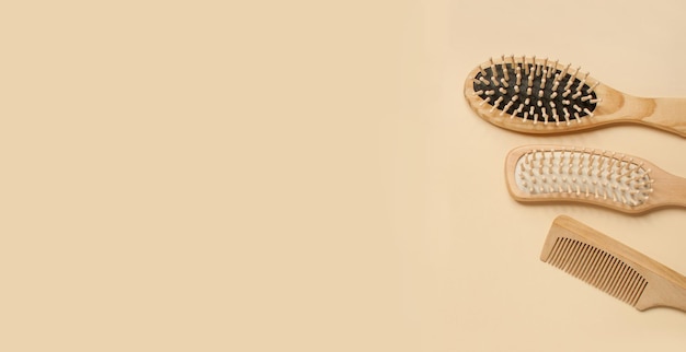 Three different wooden combs on a beige background in the form of a banner