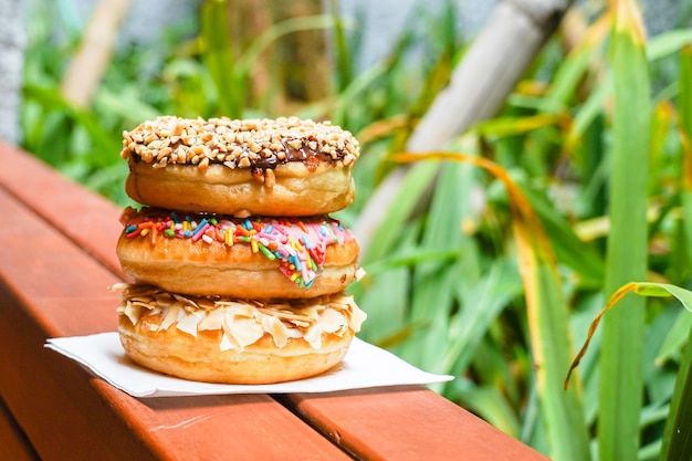 Three donuts on a table with a green background