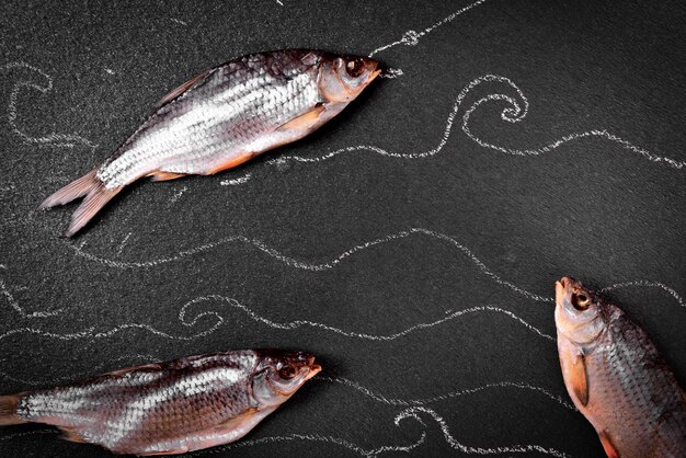 Three dried in the salt fish ram on the black surface