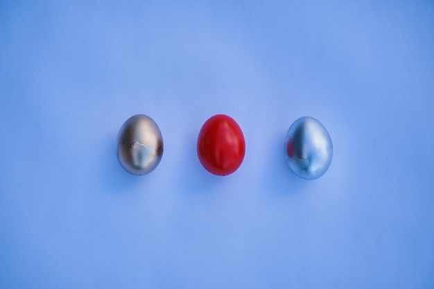 Three eggs on a blue background, one red and one red.