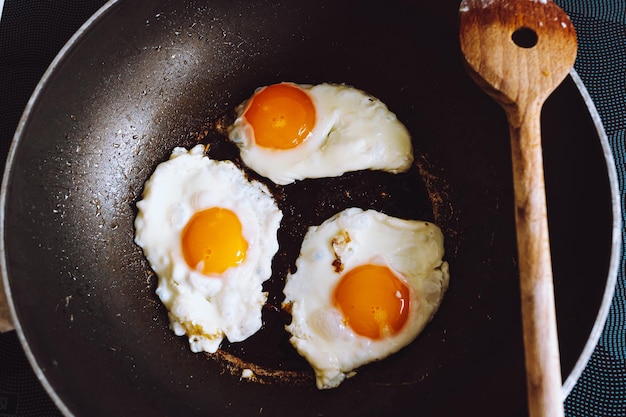 フライパンで揚げた3つの卵は、スクランブルエッグのトップビューです。健康食品、栄養価の高いおいしい朝食