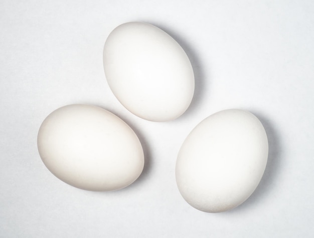 Три яйца на белом фоне Готовка Приготовление завтрака Здоровое питание