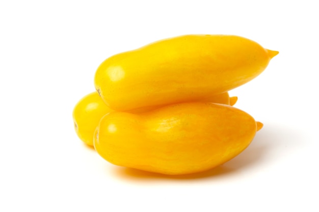 Three elongated yellow tomatoes lie on a white background.