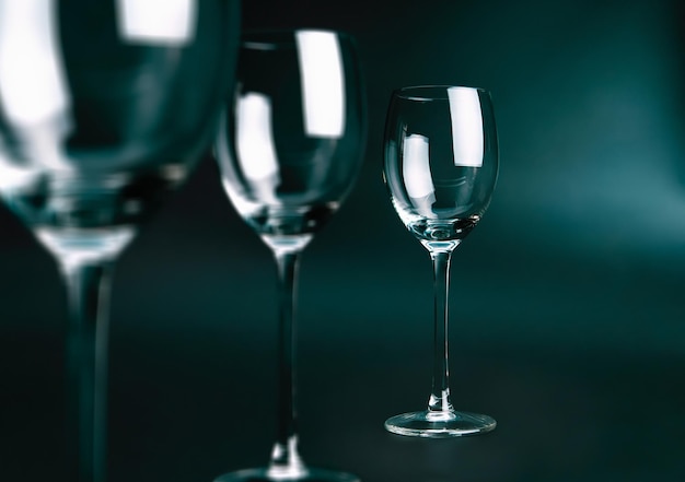 Three empty glasses on dark green background