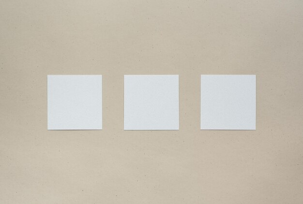 Three empty square eco paper sheets on brown background